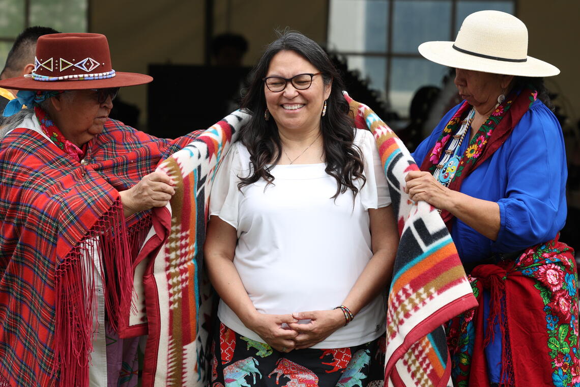 A graduate receiving their blanket during the gifting ceremony.