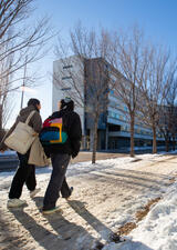 students walking on a snowy path on campus