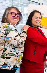 Two people shake hands with another person standing beside them