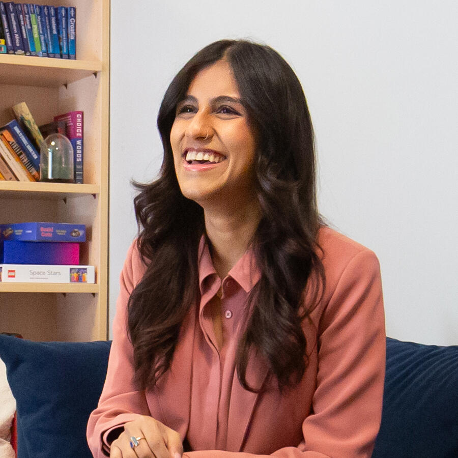 A woman sitting in front of a bookshelf