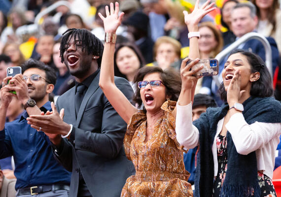 A family cheers on their graduating loved ones