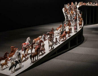 An art piece of horses walking up an incline