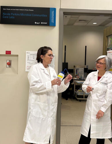 Two people stand in lab coats