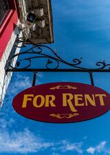 for rent sign hanging off building 