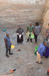 A group of people are working in a large pit