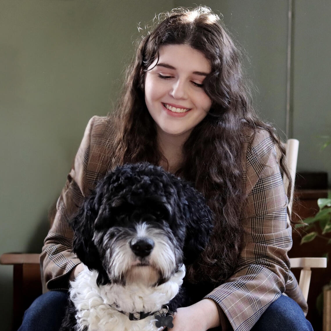 A woman with long dark hair and a dog