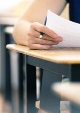 person sitting at a desk to write an exam