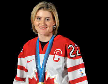 woman in a hockey jersey with a gold medal around her neck