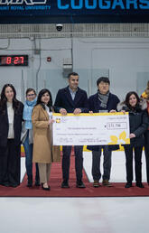 A group of people holding an oversized cheque