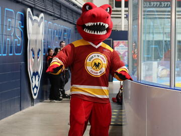 A red dinosaur in a hockey jersey