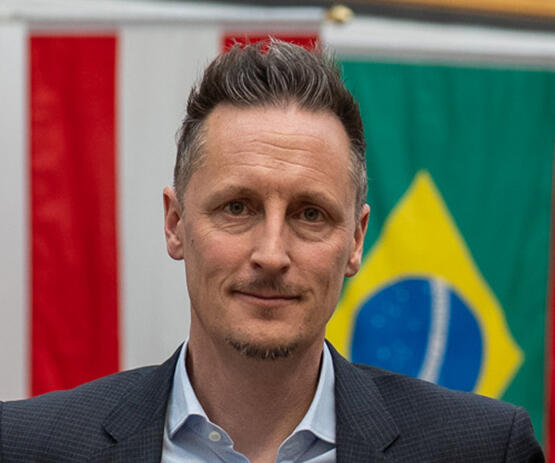 A man with short hair looks at the camera