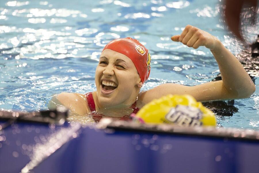 A woman celebrates in a pool