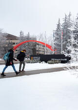 students walking on a snowy main campus pathway