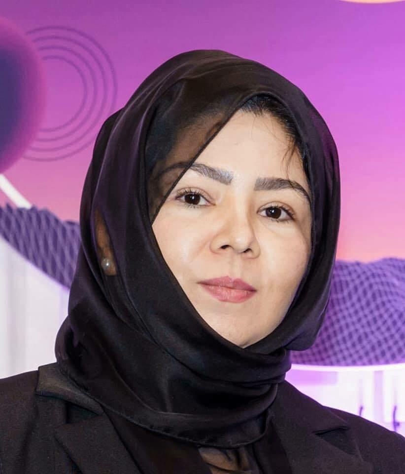 A woman wearing a black head covering looks at the camera